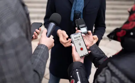 Bild zeigt Fokus auf die Mikrofone mehrere Reporter bei einem Interview