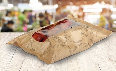 Auf einem Tisch liegen Äpfel in einer recyclingfähigen Kunststoffverpackung