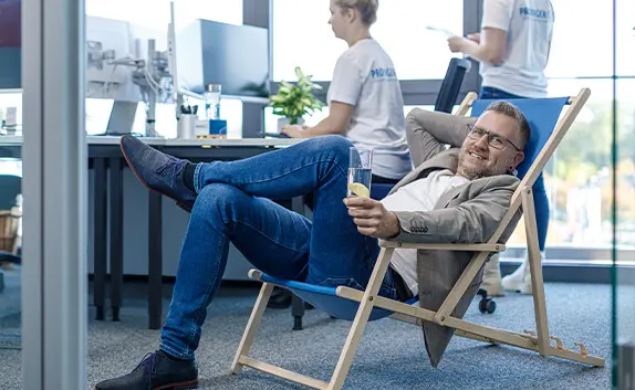Entspannter Kunde sitzt im Liegestuhl, da sich Prodinger um alles wie Logistik, E-Commerce und Wartung & Service von Verpackungsmaschinen kümmert.