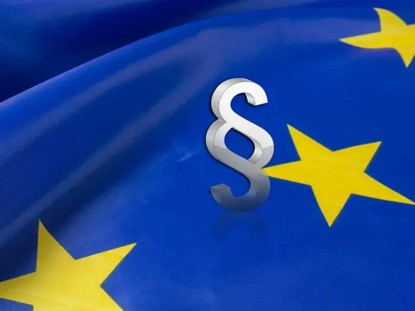 Nahaufnahme einer Europaflagge mit einem Paragrafen-Zeichen.