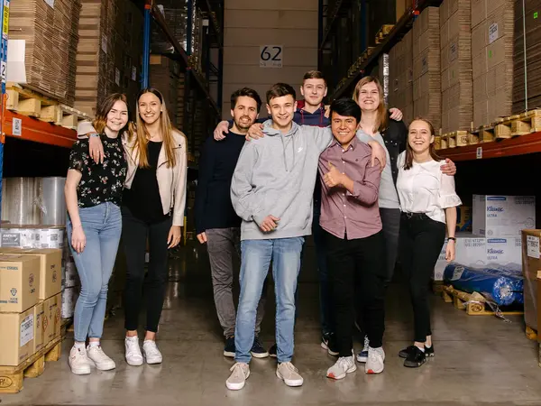 Eine Gruppe von PRODINGER Auszubildenden steht im Hochregallager.